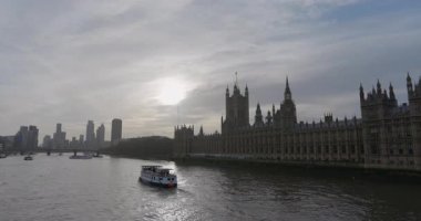 Londra 11.30.24. Gün batımında Thames Nehri 'nde süzülen bir tekne gibi Parlamento' nun ikonik evlerinin nefes kesici nehir manzarası Londra 'nın eşsiz cazibesini ve güzelliğini kusursuz bir şekilde gösteriyor.