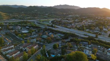 Los Angeles 'ın çarpıcı banliyölerini gösteren hava görüntüleri gür tepeler, görkemli dağlar, hareketli otoyollar ve hareketli trafik günbatımında büyüleyici bir manzara yaratıyor.