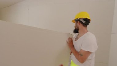 Aralarında Afro-Amerikan, İspanyol ve Kafkasyalı bireylerin de bulunduğu çeşitli inşaatçılar, bir inşaat sahasında birlikte çalışıyorlar, takım çalışması ve ev yenileme çalışmaları yapıyorlar..