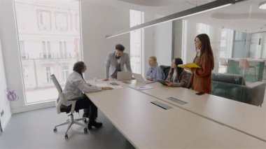 Modern bir ofiste, çeşitli yetenekli profesyonellerden oluşan bir grup, ortak başarı ve yenilikçi büyüme için teknolojiyi ve takım çalışmasını koz olarak kullanarak beyin fırtınası ve strateji oluşturmaya çalışıyor.