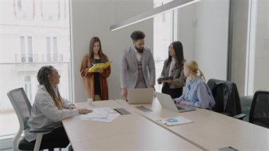 Çeşitli kendini işine adamış profesyoneller modern bir ofiste, tartışmalar ve faaliyetler yoluyla takım çalışması ve yeniliklerini sergileyerek, üretkenlik ve yaratıcılığı geliştirerek işbirliği yaparlar.