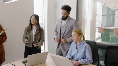 Modern bir ofiste, çeşitli profesyoneller dizüstü bilgisayar kullanırken, işbirliğini desteklerken ve herkesin yararına olan başarılı proje sonuçları için üretkenliği artırırken tartışmalara dahil oluyorlar.