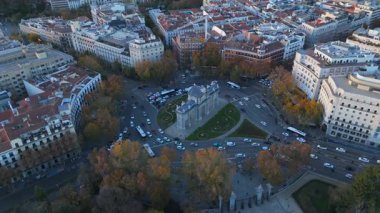 Madrid 'deki Puerta de Alcala' nın büyüleyici güzelliğini büyüleyici günbatımı saatinde kuş bakışı görüntüden yakala. Bu ikonik simgeyi, canlı şehir hayatı arasında gururla dururken tecrübe edin. İspanya