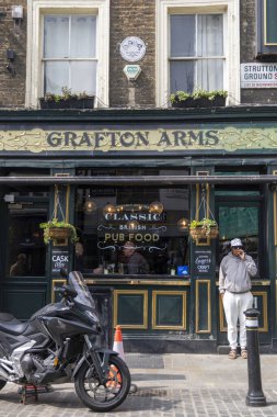 Londra 30.04.2025. Londra 'daki Grafton Arms barının dış kesiminde geleneksel mimari ve klasik bir motosiklet bulunmaktadır.