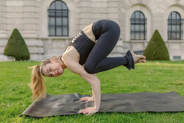 Orta yaşlı bir kadın, güçlü, dengeli ve kendini spora adamış güzel doğal bir ortamla çevrili, kendine güvenerek yoga pozunu sergiliyor.