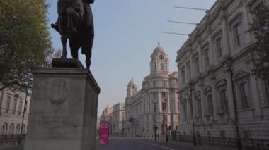 Londra 04.28.2025. Serene view, büyüleyici bir caddedeki tarihi bir binanın önündeki heykeli ön plana çıkarıyor. Bölgelerin mimari zarafetini sergiliyor ve kentsel manzaranın genel çekiciliğini artırıyor.