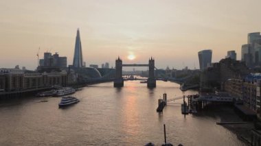 Çarpıcı ve nefes kesici bir hava fotoğrafı Tower Köprüsü 'nü ve ikonik Londra siluetini alacakaranlıkta yakalar. Thames Nehri' nin huzur dolu güzelliğini ve çevresini güzelce gözler önüne serer.