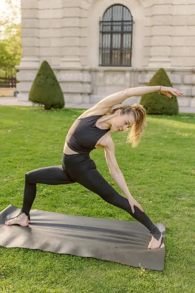 Orta yaşlı bir kadın sakin ve güzel bir ortamda yoga yapıyor. Etkileyici esnekliğini ve derin sakinliğini gösteriyor.