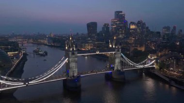 Büyüleyici bir alacakaranlık fotoğrafı Tower Köprüsü 'nü ve Londra' nın Thames Nehri üzerindeki ufuk çizgisini yakalar ve şehrin canlı alacakaranlık ışığı görüntüsünü resimli ve romantik bir sahnede gösterir.