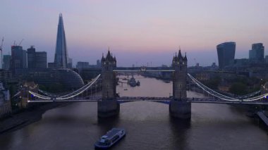 Alacakaranlıkta parlayan ikonik Tower Köprüsü 'nün nefes kesici hava perspektifi Thames Nehri boyunca uzanan çarpıcı ve güzel Londra siluetini kusursuz bir şekilde aydınlatıyor.