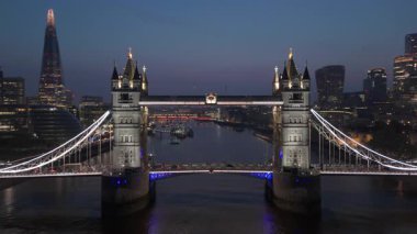 Hava aracı görüntüleri ikonik Tower Köprüsü 'nü vurguluyor, gece aydınlanıyor, Thames nehri boyunca Londra' nın canlı siluetine vurgulanıyor, UK 'ların dinamik başkentinin özünü yakalıyor.