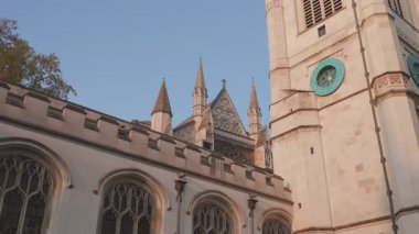 Çarpıcı tarihi bir kilisenin büyüleyici manzarası, karmaşık gotik mimari detaylarının bir örneğidir. Süslü kuleler ve zamansız güzellikler, hepsi açık mavi gökyüzünün arka planına kurulmuştur.