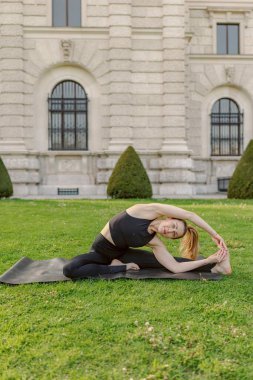 Sakin bir açık hava ortamında, bir kadın doğayla bütünleşirken yoga yapar, esneklik ve sükunet gösterir. İç huzuru, farkındalığı ve güçlü bir zihin-ruh bağlantısını temsil ediyor.