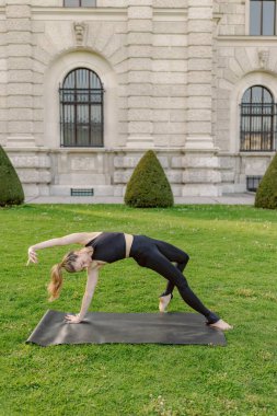 Bir kadın, doğa yeşillik ve sükunetle çevrili inanılmaz derecede çarpıcı ve sakin bir yerde, esnek ve dayanıklılığını güzel bir şekilde sergiliyor.