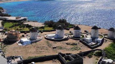 Mikonos Adaları 'nın ikonik yel değirmenleriyle parıldayan mavi suların çarpıcı görüntüsü. Yunanlıların büyüleyici kıyı manzaraları her ziyaretçiyi büyülüyor.