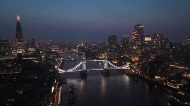Hava aracı görüntüleri, Londonların alacakaranlıkta gökyüzüne yükselişini, ikonik Tower Köprüsü 'nü ve canlı şehir yaşamını resimli Thames nehrinin üzerinde güzel bir şekilde yakalar.