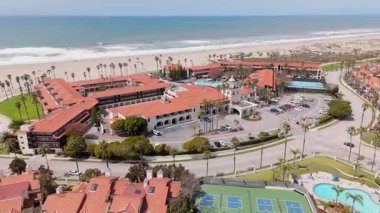 Hava çekimlerinde Oxnard, Kaliforniya 'daki çarpıcı sahil ve lüks tatil beldesi gösteriliyor. Davetkar havuzlar, palmiye ağaçları ve rahatlama ve eğlence için mükemmel bir kaçış yeri.