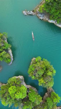 Açık mavi suları, görkemli kireçtaşı tepelerini ve Tayland 'ın Phuket Adası' nı tanımlayan yemyeşil alanları gösteren nefes kesici hava görüntülerinin nefes kesici güzelliğine kendinizi daldırın.