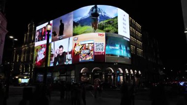 Londra 04.28.2025. Piccadilly Sirki 'nin geceleri heyecan verici atmosferinin zamanlaması, ikonik simgeleri aydınlatan çarpıcı LED reklamları sunuyor.