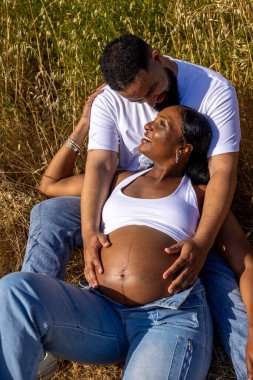 Afrika kökenli Amerikalı bir çift, doğada bir yaz gününün tadını çıkarıyor. Koca, hamile eşinin karnına sevgiyle sarılıyor ve bu özel mutluluk ve sıcaklığı kutluyor.