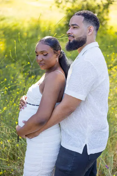 Sıcak bir yaz gününde, sevgi dolu bir çift doğanın tadını çıkarır. Koca, karılarının hamile karnını kucaklıyor. Geleceği için derin bir sevgi ve heyecanı yansıtıyor.