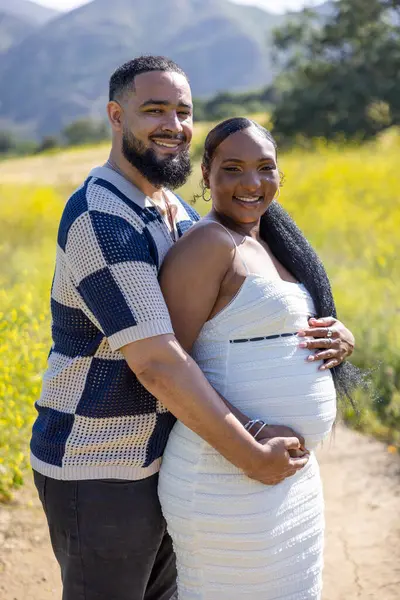 Afrika kökenli Amerikalı bir çift dışarıda güzel bir yaz gününün tadını çıkarıyor, neşeli hamilelik beklentilerini kucaklıyor ve bu hayret verici doğal ortamda geleceklerini iple çekiyorlar.