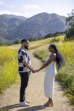 Birbirlerine derinden bağlı neşeli bir çift görkemli dağlarla ve çiçeklerle dolu sakin bir açık hava ortamını kucaklıyor. Sevgi ve kahkahayla dolu güzel anları kutluyorlar.