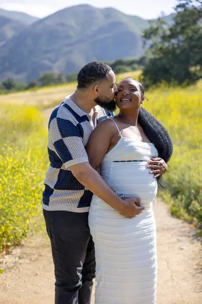 Bu güneşli günde, sevecen bir Afro-Amerikan çifti hamileliklerini sevinçle kutlarken, mutluluğu ve bu özel anda derin bir duygusal bağı paylaşıyor.