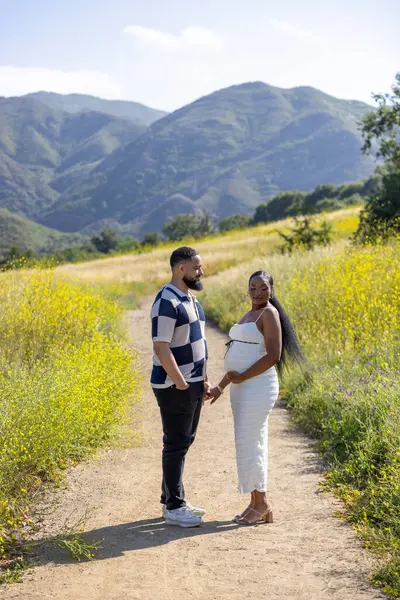 Güzel ve neşeli bir Afro-Amerikan çifti sıcak ve güneşli bir yaz gününün tadını çıkarıyor. Doğaları gereği inanılmaz güzellikte ve canlı bir manzarayla çevrili olan hamileliklerini kutluyorlar.