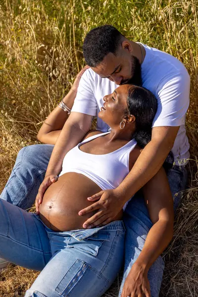 Afrika kökenli Amerikalı bir çift yaz güneşi altında sevinçle hamileliklerini kutluyor. Birbirlerini kucaklıyorlar. Sevgi, neşe ve ailelerinin büyümesini bekliyorlar.