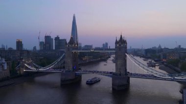 İkonik Tower Köprüsü 'nün çarpıcı hava görüntüleri alacakaranlıkta güzelce aydınlatılıyor. Huzurlu Thames Nehri' nin üzerinde mükemmel bir şekilde yansıyan Londra siluetini gözler önüne seriyor.