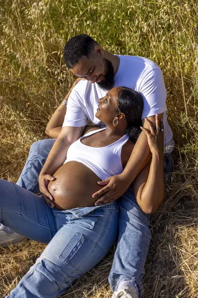 Afrika kökenli Amerikalı bir çift açık havada güneşli bir günün tadını çıkarıyor. Kocası hamile eşinin karnını kucaklıyor. Yeni aile üyelerine hazırlanırken sevgilerini ve desteklerini gösteriyorlar.