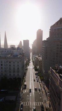 San Fransisco 'nun canlı sokaklarını, sabah sıcacık ışıklarıyla güzelce aydınlatılan ve şehrin dinamik ve enerjik atmosferini aydınlatan çeşitli etkinliklerle gösteren bir hava görüntüsü var.