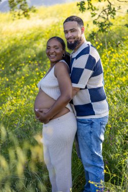 Işıl ışıl bir yaz gününde, bir çift hamileliklerini kutlar. Kocalar eşlerine sarılır. Bebek çarpması, yeşillik, mutluluk ve beklentinin somutlaştığı açık hava ortamında.