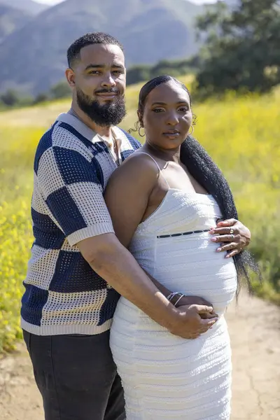 Neşeli bir çift, güzel ve sakin bir açık hava yaz ortamında birlikte geçirdikleri heyecanlı hamileliği kutluyor. Bu onların derin mutluluğunu ve birbirleriyle olan derin bağlarını güçlendiriyor.