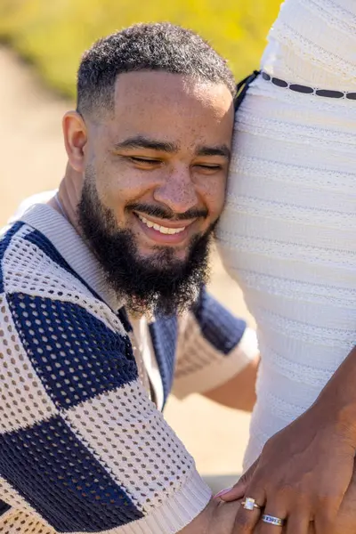 Afrika kökenli Amerikalı bir çift canlı bir yaz ortamında hamileliklerini neşeyle kucaklıyor. Ailelerinin yeni gelişi ve gelecekteki gelişimi için derin bağlantılarını ve heyecanlarını yansıtıyor.