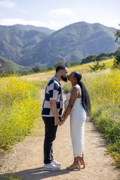 Sevgi dolu hamile bir çiftin, çarpıcı manzaralı bir ortamda, birbirlerine ve doğanın güzelliklerine sarıldığı güzel bir an.