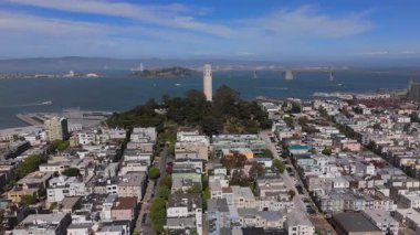 Sersemletici hava görüntüleri San Francisco siluetinin etkileyici bir görüntüsünü sunuyor. Şehrin ünlü bir simgesi olan Coit Kulesi 'nin yanındaki ikonik yüksek binaları vurguluyor.