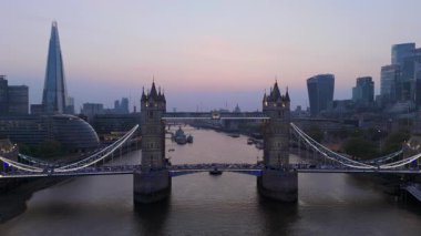 Bu çarpıcı hava görüntüsü alacakaranlıkta muhteşem Tower Köprüsü 'nü yakalıyor. Londra' nın modern silueti, Thames nehri boyunca güzel bir şekilde sergileniyor. Her ziyaretçi için bir işaret.