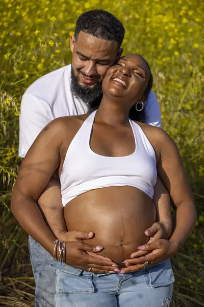 Sevgi dolu bir çift, hamileliklerini kutlamak için yaz tatilini dışarıda geçirir. Koca, karılarına sarılıyor. Derin bağlarını ve sevgilerini gösteriyor. Canlı çiçekler ve yeşilliklerle çevrili.