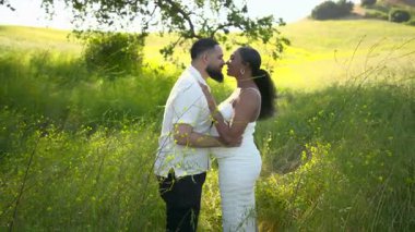 Güzel, doğal bir ortamda, sevecen bir Afro-Amerikan çifti derin sevgi ve sevinçlerini paylaşarak ebeveynliği birlikte karşılamaya hazırlanıyorlar.