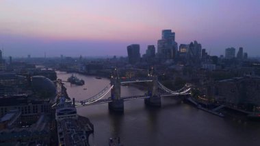 Gökyüzü fotoğrafı ikonik Tower Köprüsü 'nü ve alacakaranlıkta canlı Londra siluetini yakalıyor. Huzurlu Thames Nehri' ne karşı güzelce aydınlatılıyor. Seyirciler için nefes kesici bir manzara yaratıyor.