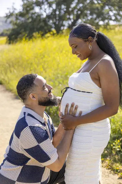 Neşeli ve beklenen bir çift, yazın sıcacık kucaklamasında, doğanın güzelliği arasında sakin bir anı yakalar. Ebeveynliğe doğru heyecanlı yolculuklarını derin bir sevgi ve bağla kutlarlar.