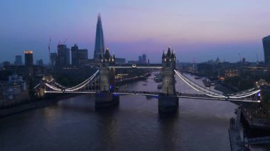 Tower Bridge 'in alacakaranlık gösterisi Londons' un Thames Nehri 'ne karşı siluetini gösteren hava aracı görüntüleri tüm büyüleyici akşam saatlerinde şehrin güzelliğini vurguluyor.