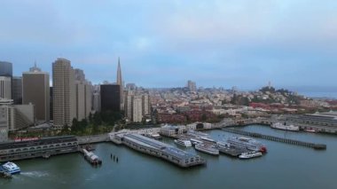 Güzel San Francisco siluetinin ve şehrin simgesel mimarisinin özünü büyüleyici sabah sisiyle birlikte yakalayan parıldayan körfezinin nefes kesici hava görüntüsünü alın.