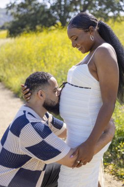 Bebek bekleyen sevgi dolu bir çift, doğada güzel bir yaz gününün tadını çıkarıyor. Aşklarını kutluyor ve yeni aile üyelerinin gelişini sabırsızlıkla bekliyor. Umut ve neşe getiriyor.