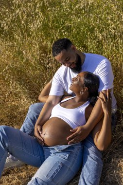 Afrika kökenli Amerikalı bir çift birlikte güzel bir yaz anının tadını çıkarıyor. Koca, hamile eşinin karnını sevgiyle kucaklıyor. Büyüyen aileleri için sevgi ve beklentiyle dolu.