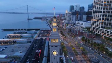 Hava fotoğrafında San Francisco 'nun göz kamaştırıcı silueti ve kıyıları görülüyor. Işıklar ve sisle aydınlatılıyor. Şehrin canlı özünü aydınlatan büyüleyici bir manzara yaratıyor.