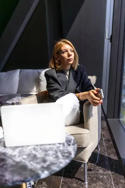 Modern dekor ve teknolojiyle çevrili şık ofisinde profesyonel bir kadın, iş dünyası için ideal bir ortam yaratıyor, yaratıcılığı, verimliliği ve etkili toplantıları teşvik ediyor.