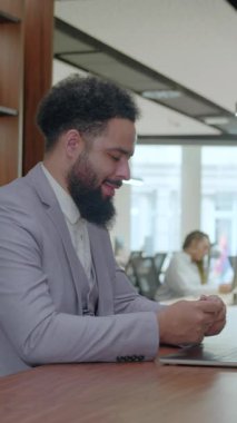 İşbirliği için tasarlanmış şık bir ofiste, bir iş adamı dizüstü bilgisayarı üzerinde çalışırken, destekleyici bir meslektaşı projeyi geliştirmek için değerli görüşleri ve yaratıcı fikirleri paylaşıyor.